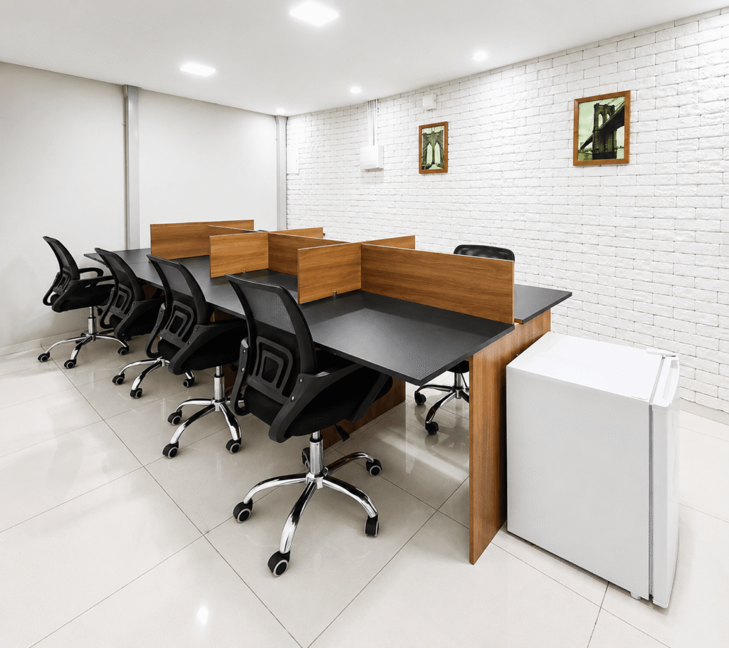 Espaço compartilhado da Elo Coworking em Betim com mesa ampla, cadeiras de escritório, armários e parede branca decorada.
