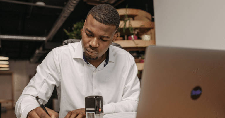 Profissional utilizando notebook e smartphone em ambiente de coworking para empreendedores, em imagem do blog Elo Coworking Betim.